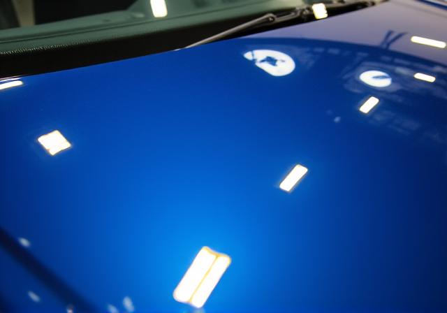 A deep, glossy reflection on the hood of a blue Audi after ceramic coating